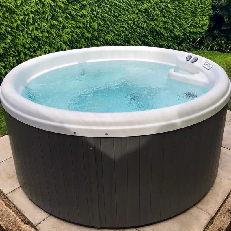Impulse DP round hot tub filled with water - outdoor hot tub for UK homes and gardens - Balboa hot tub