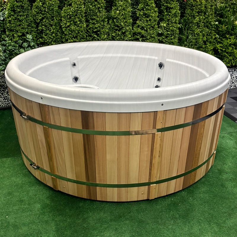 Real Cedar Wood Impulse DP round electric hot tub in a landscaped garden setting